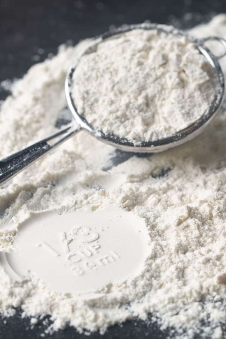 Close-up of flour on a grey background with a small sieve