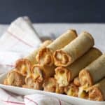 A stack of New Zealand cheese rolls on a white plate.