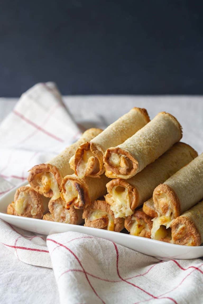 A stack of New Zealand cheese rolls on a white plate.