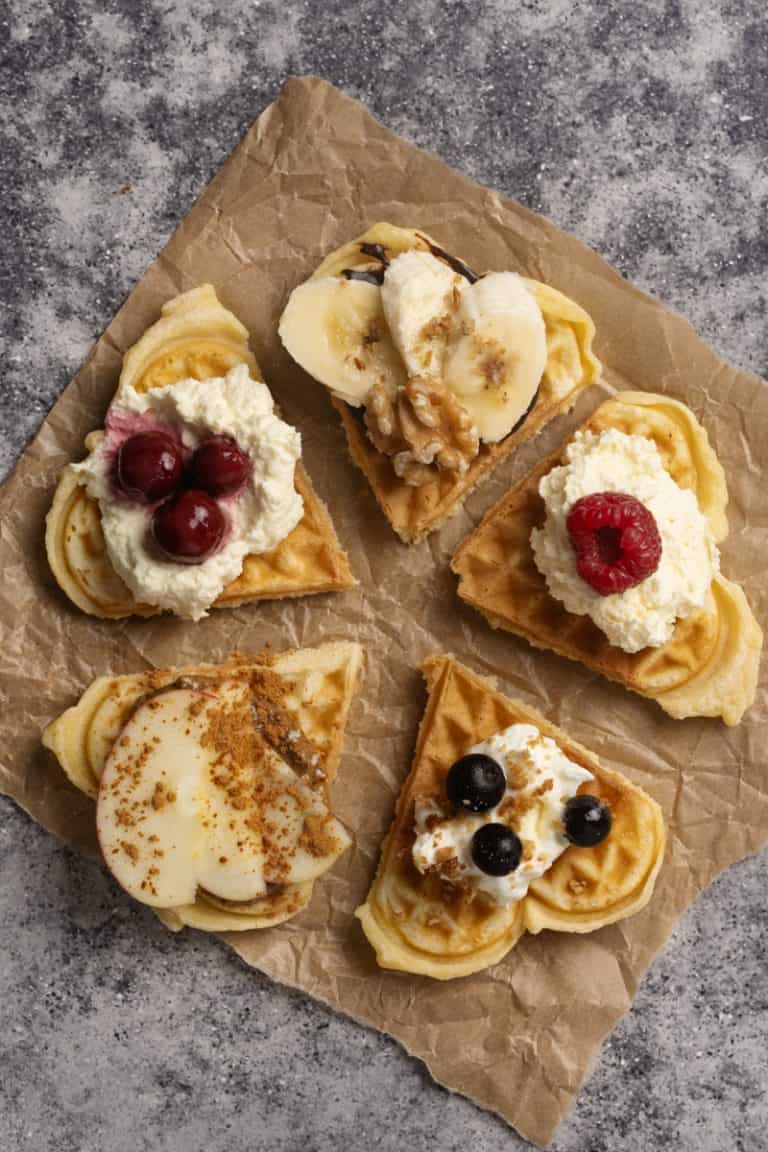 A waffle in 5 different pieces with different waffle toppings.