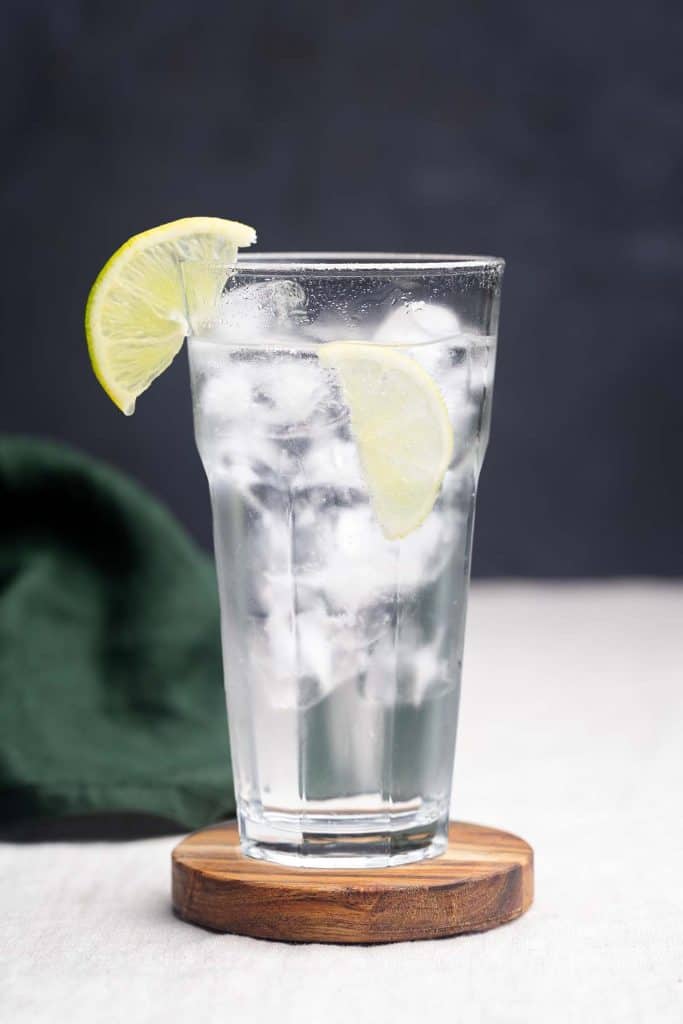 A glass of soda water with a slice of lemon. Moody aesthetic.