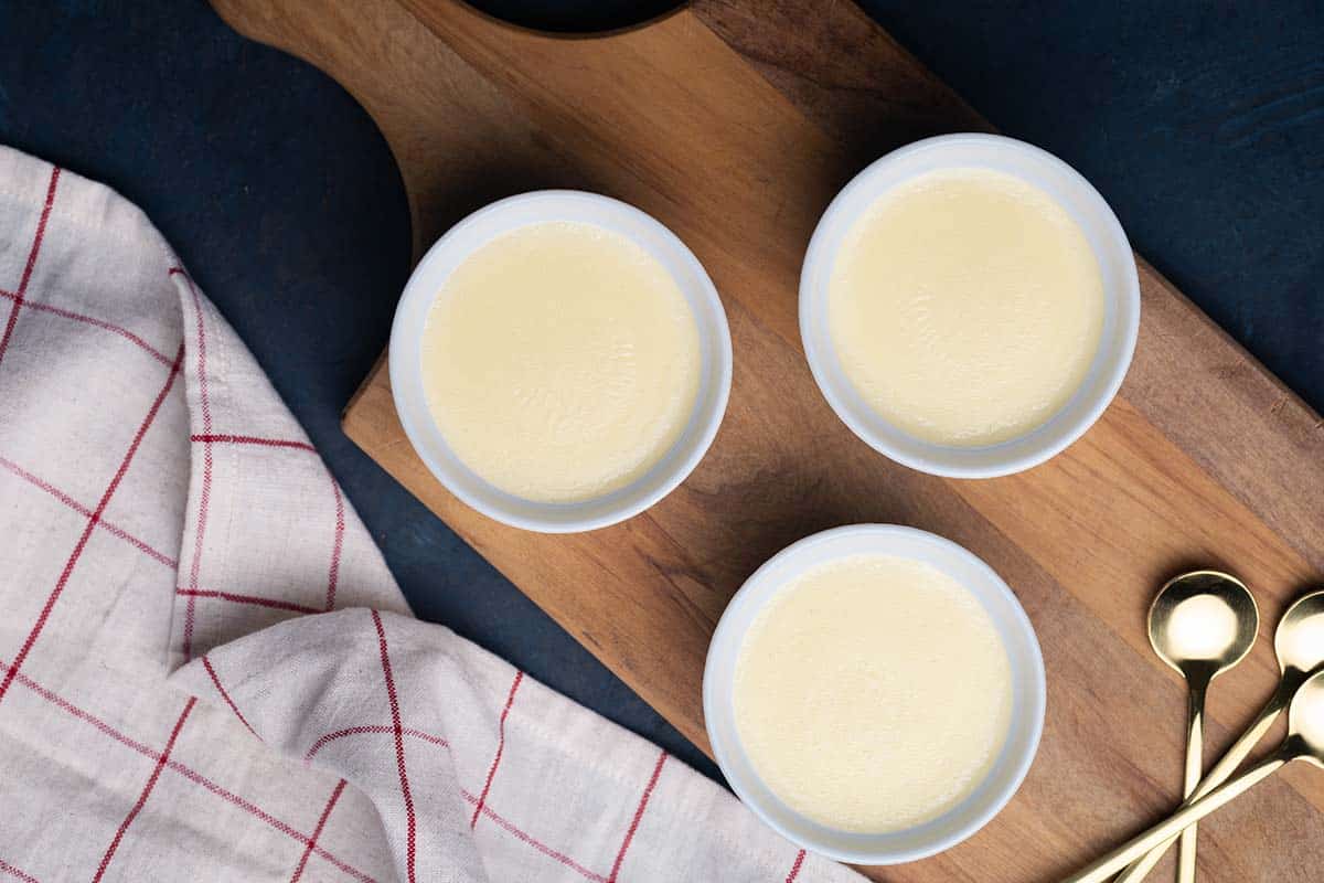 Three ramekins with creamy semolina pudding and different toppings.