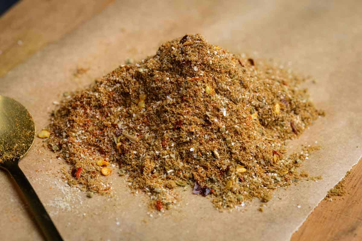 A pile of homemade burrito seasoning on a wooden board.