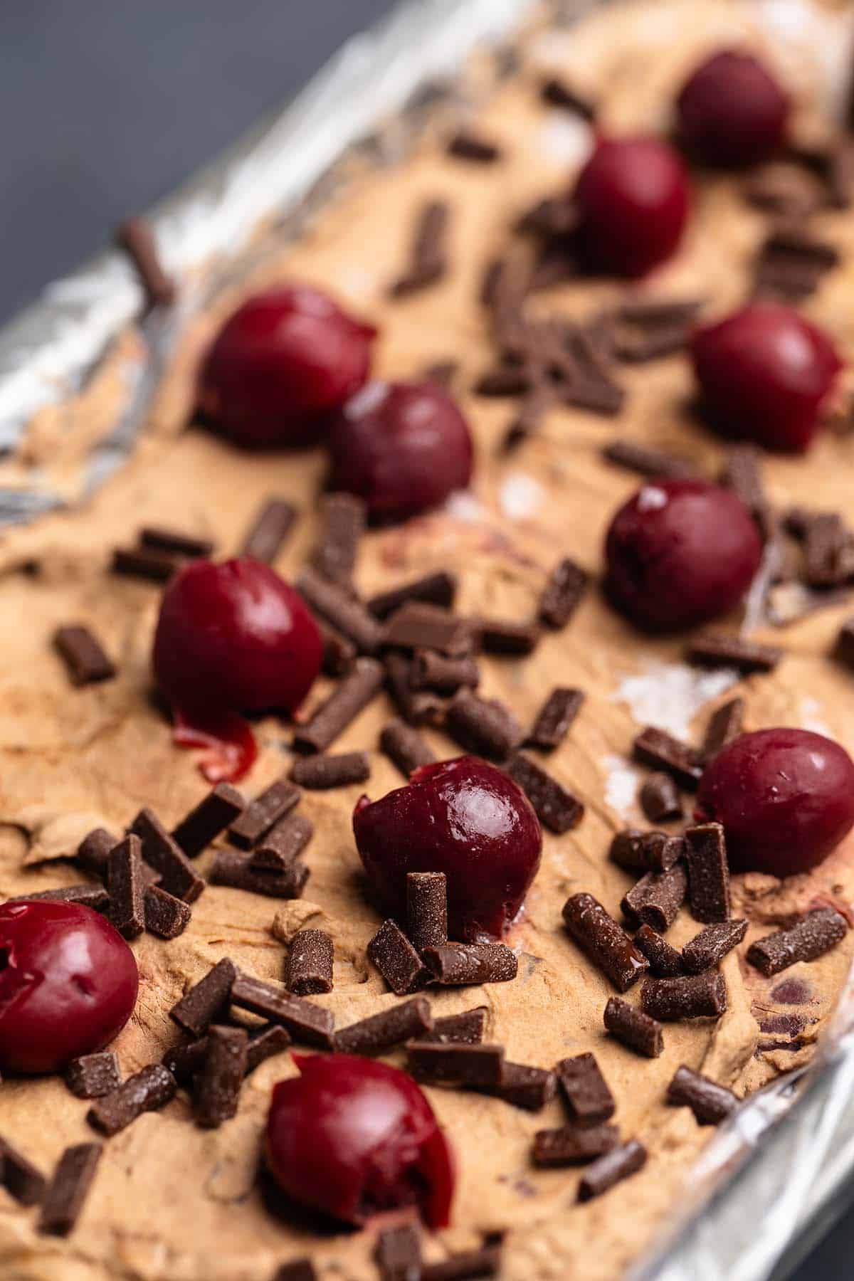 Condensed milk chocolate cherry ice cream in a container.