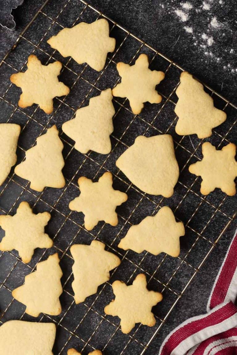 Traditional German butter cookies on a wire rack. Dark background.