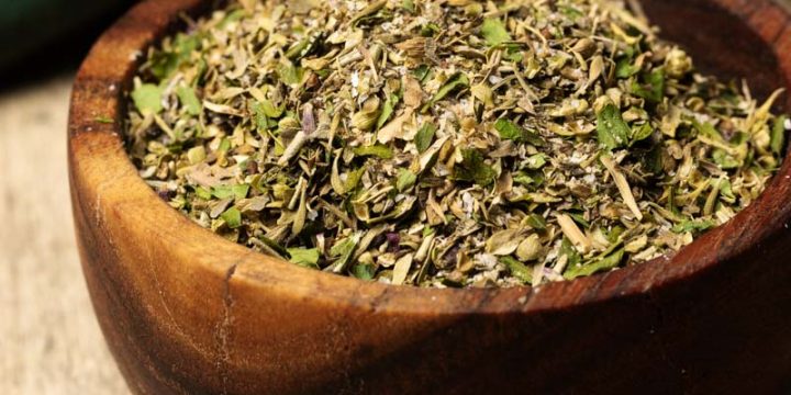 A wooden bowl filled with mediterranean seasoning.