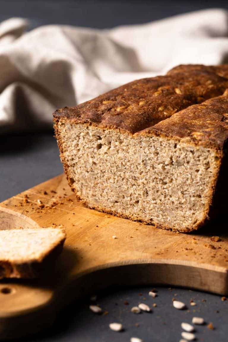 A seeded rye bread on a wooden board.