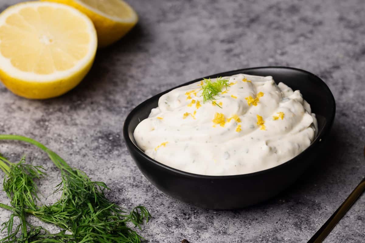 A black bowl filled with lemon dill dressing.