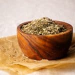 A wooden bowl filled with homemade Tuscan seasoning.