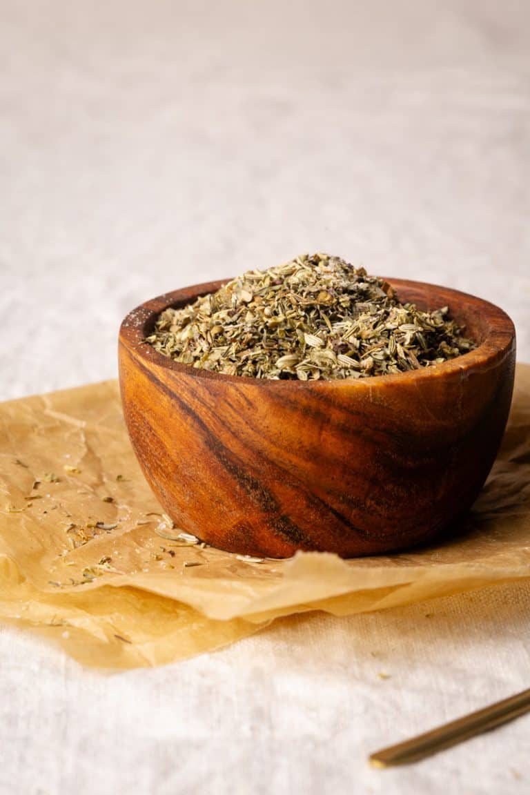 A wooden bowl filled with homemade Tuscan seasoning.