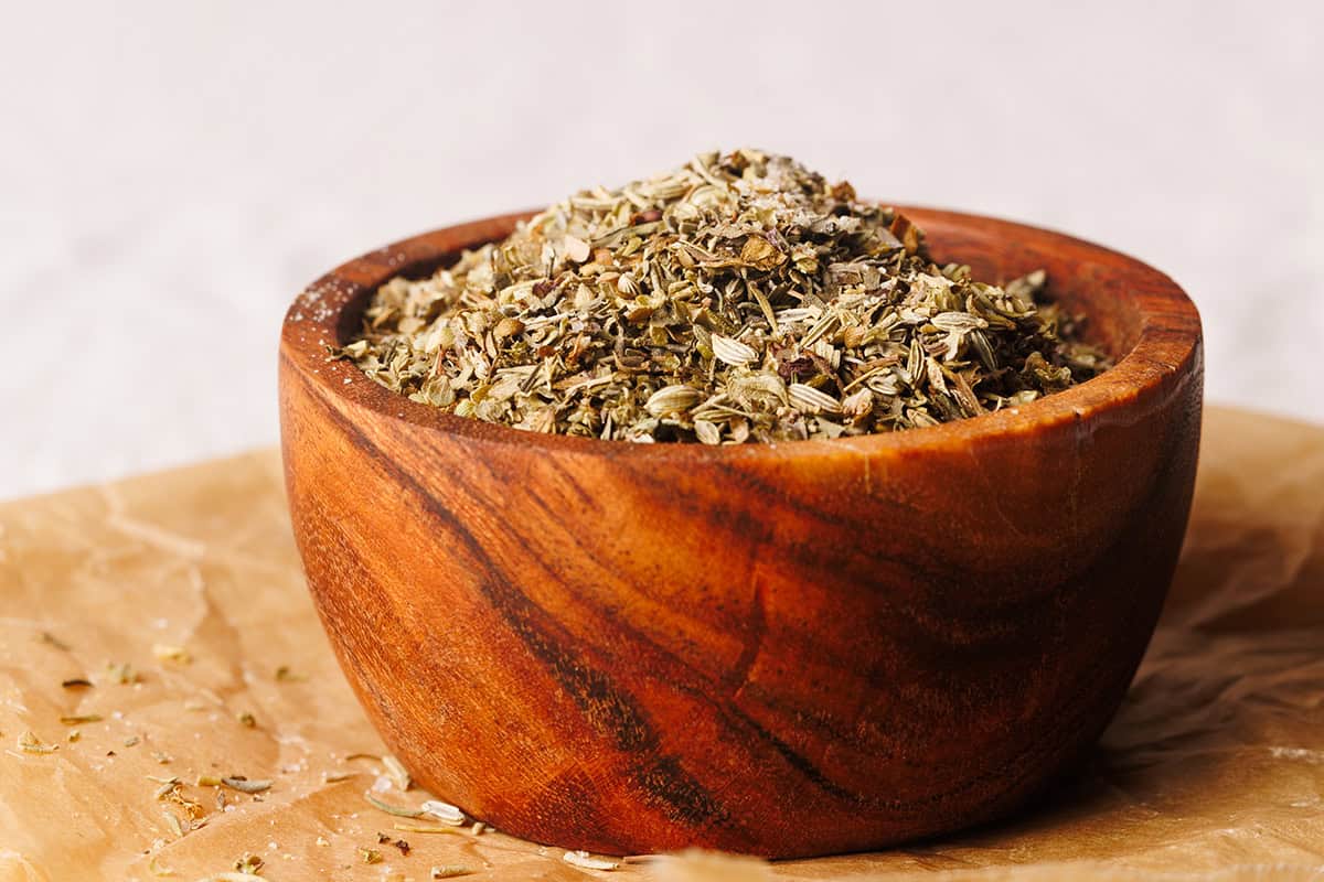 A wooden bowl filled with Tuscan seasoning.