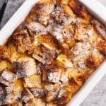 French toast casserole top down in a white baking dish.