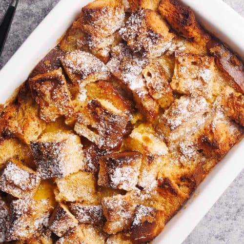 French toast casserole top down in a white baking dish.