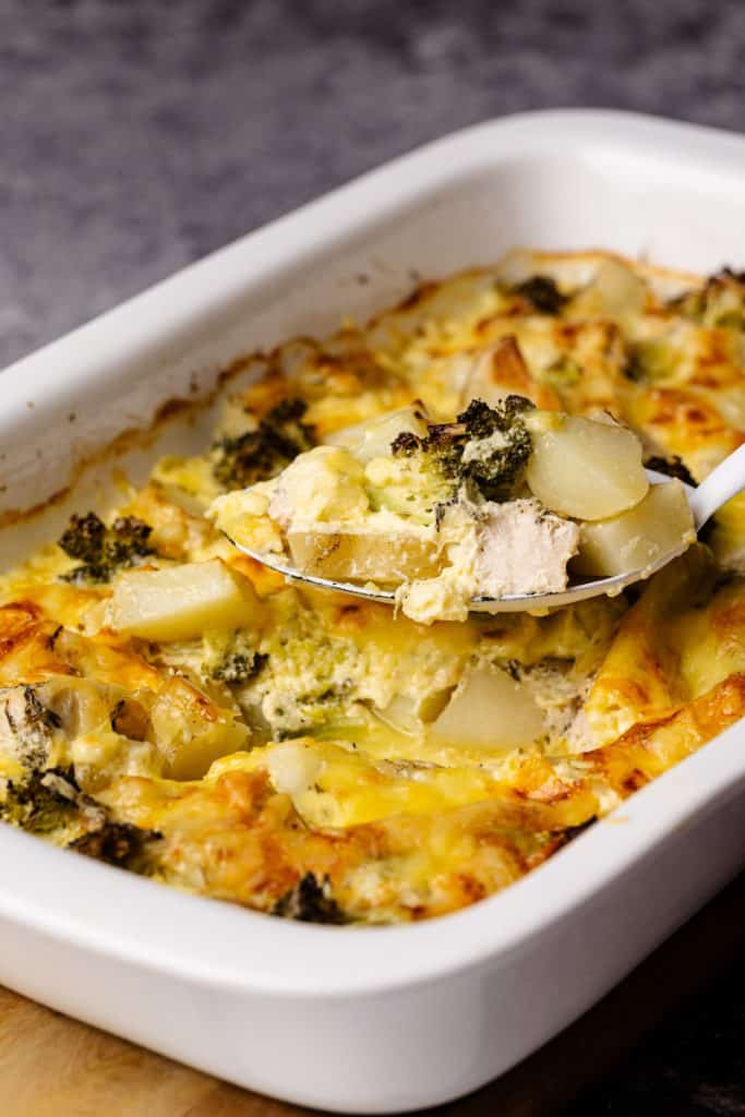 Chicken Potato Casserole being scooped out of a white casserole dish.