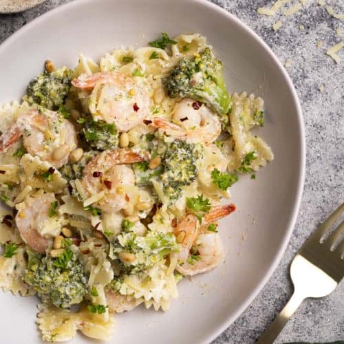 A white pasta bowl filled with shrimp broccoli pasta.