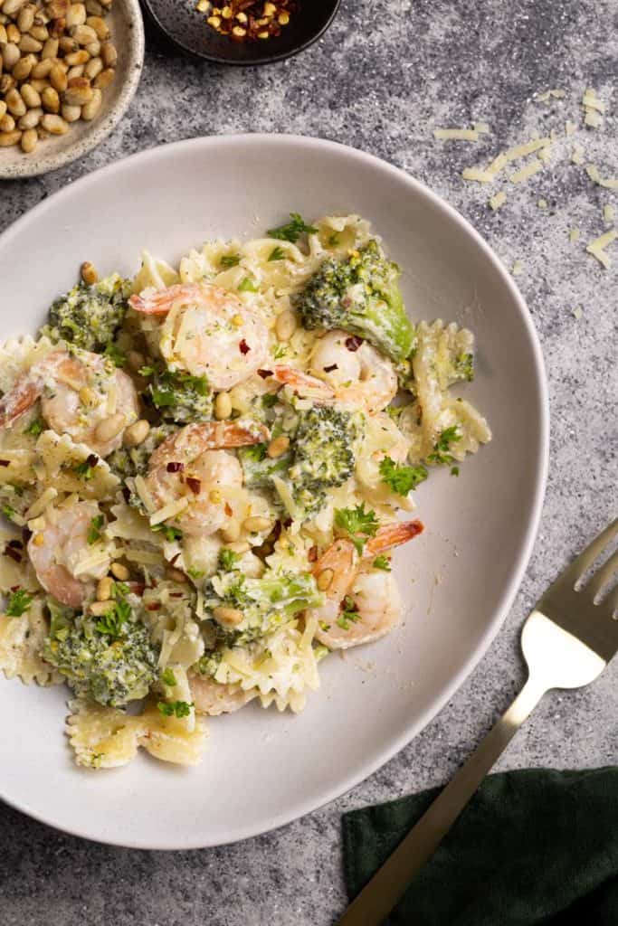 A white pasta bowl filled with shrimp broccoli pasta.