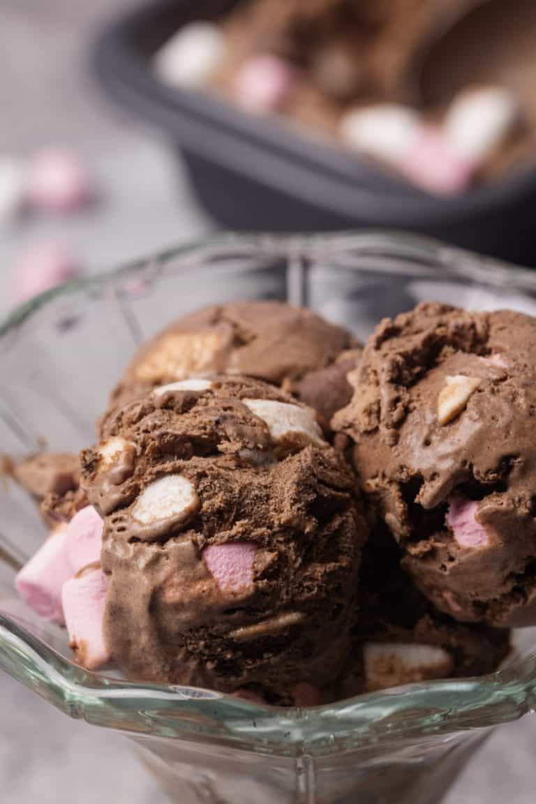 Three scoops of chocolate marshmallow ice cream in a dessert glass.