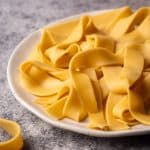 Fresh ribbon pasta on a white plate.