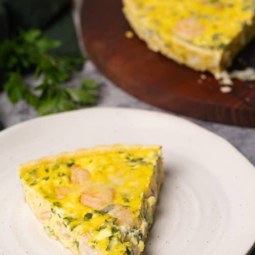 Shrimp quiche slice on a white plate.