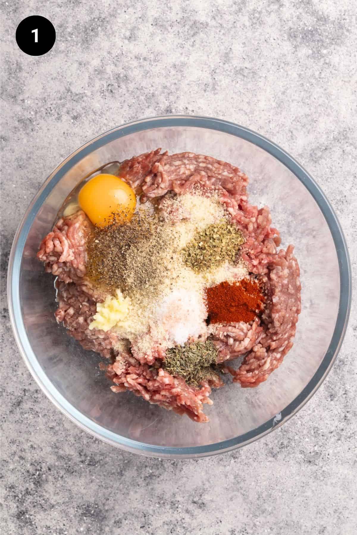Meatball ingredients in a glass mixing bowl.