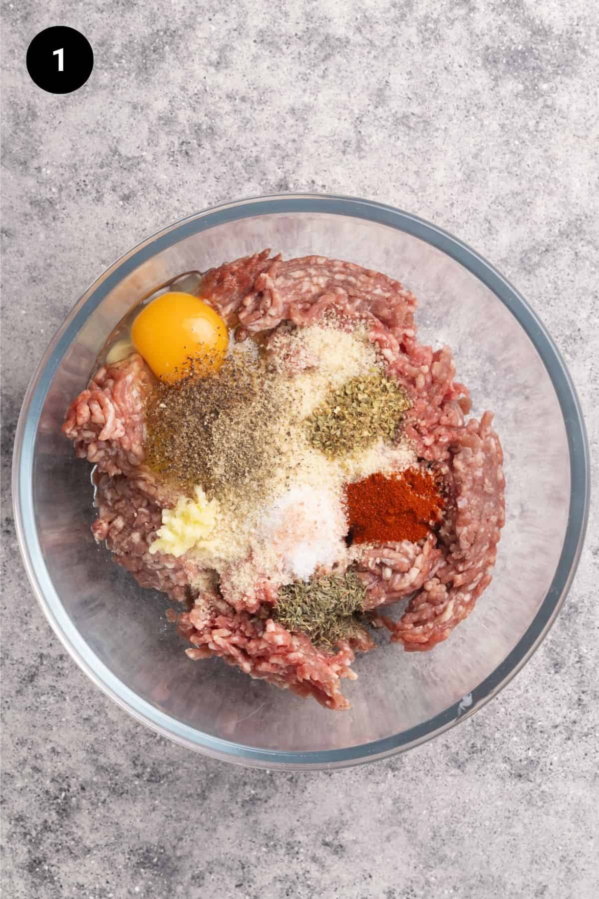Bowl with ingredients including ground lamb to make lamb meatballs.