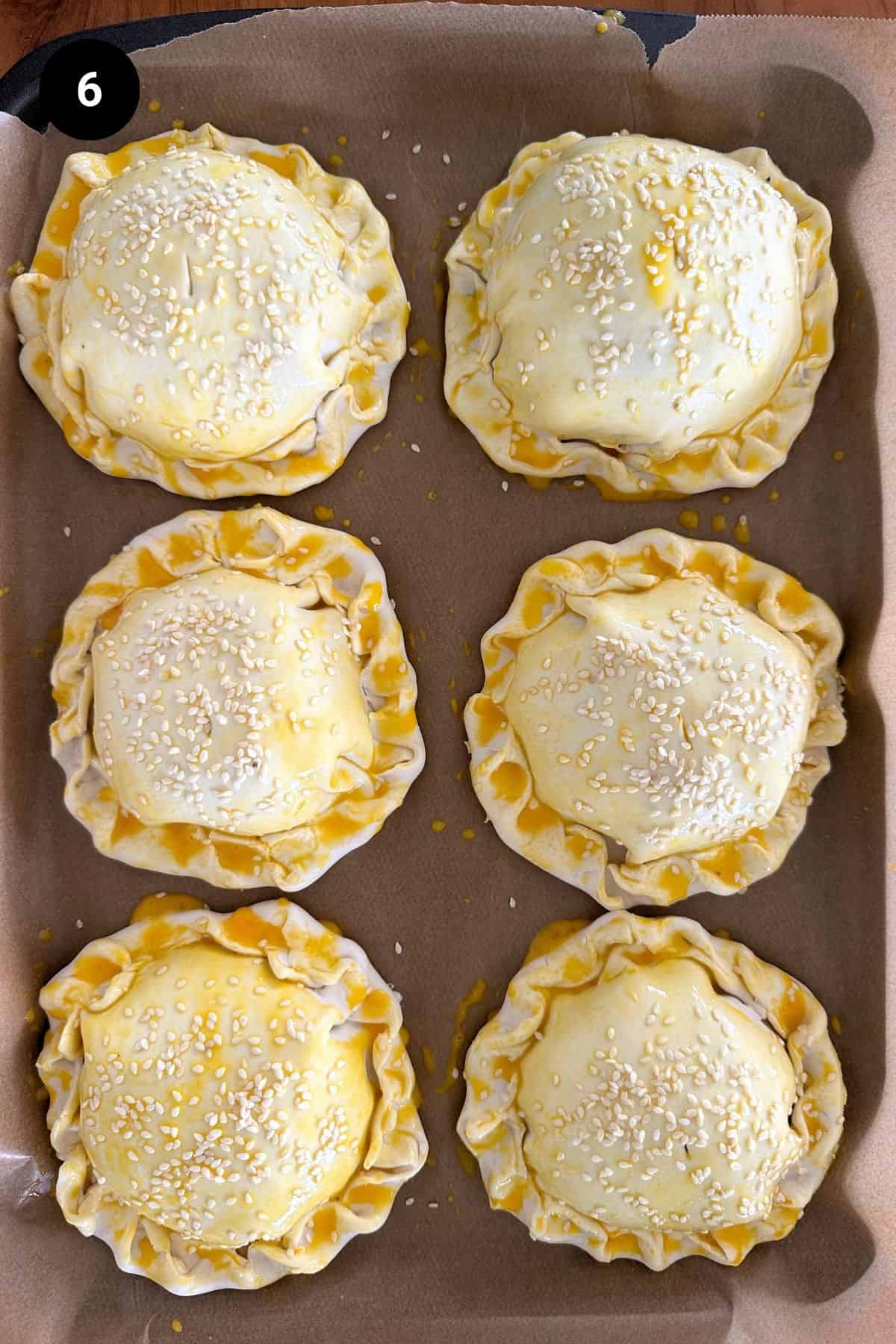 Unbaked lamb wellingtons on a baking tray.