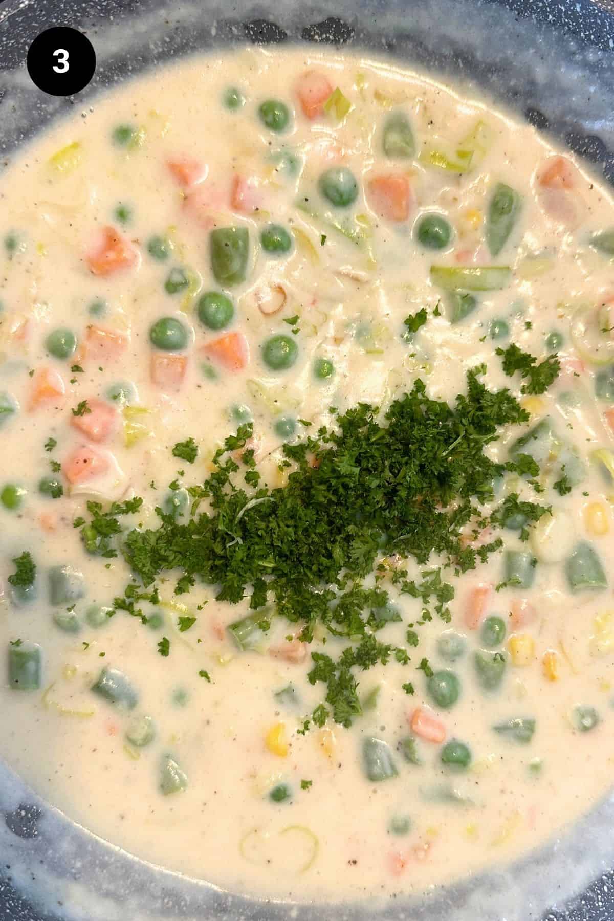 A pan filled with creamy vegetable filling, parsley shown.