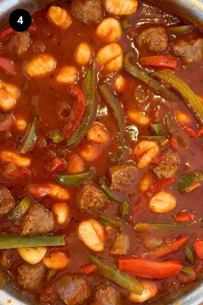 Italian goulash with gnocchi being cooked in a large pan.
