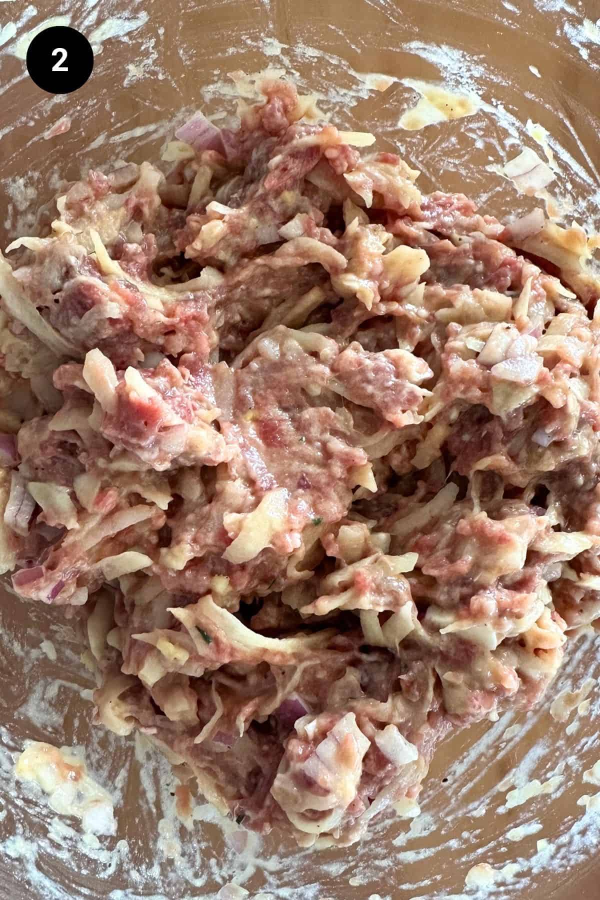 Beef fritter mixture in a glass bowl.
