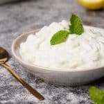 Cottage cheese tzatziki in a small bowl with a golden spoon.