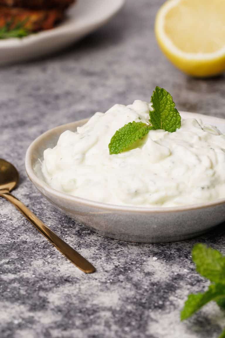 Cottage cheese tzatziki in a small bowl with a golden spoon.