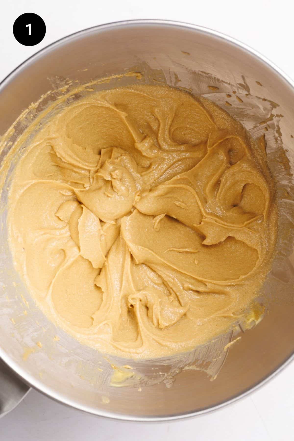 Butter and sugar creamed in a metal bowl.