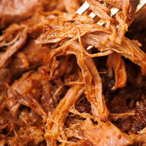 Close-up of the pulled lamb with a golden fork.
