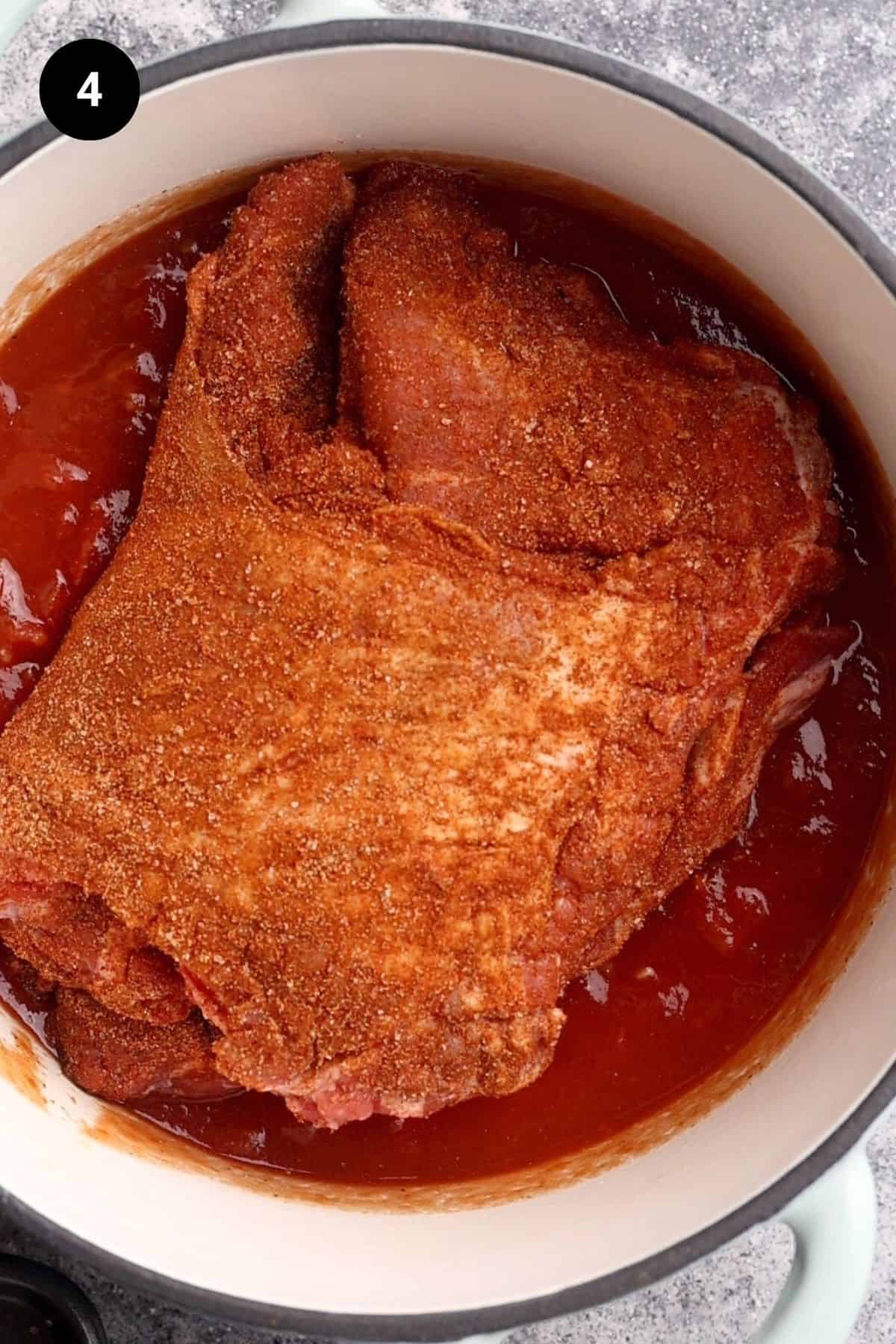 Lamb with dry rub added to the sauce in the Dutch oven.