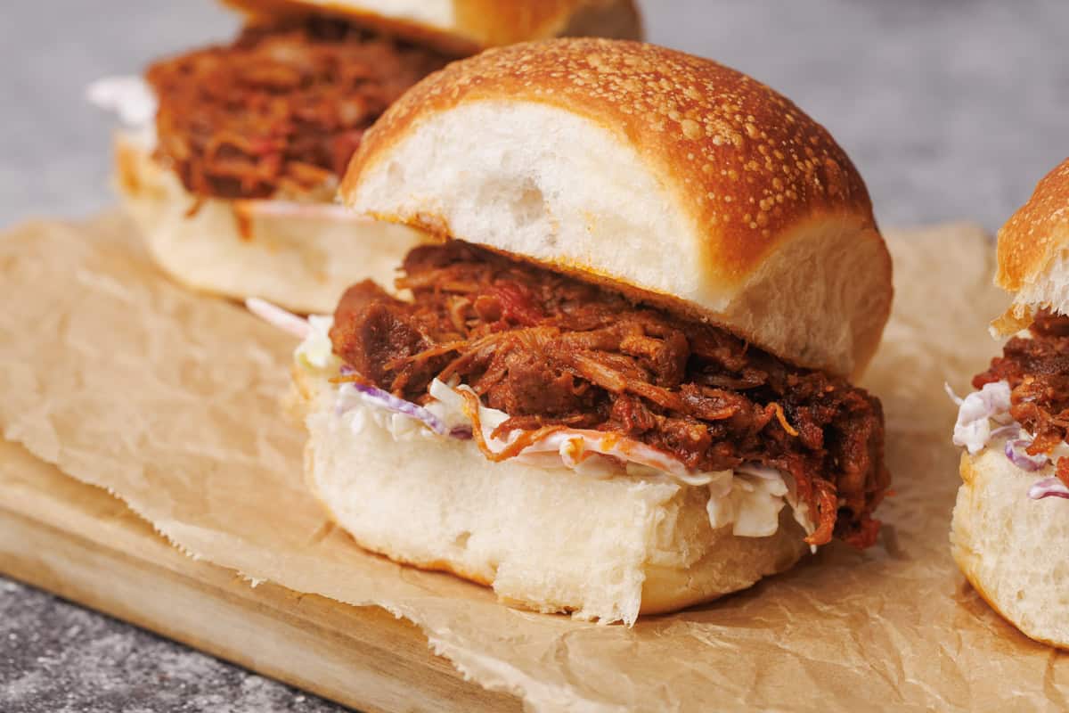 Pulled lamb burgers on a wooden board.