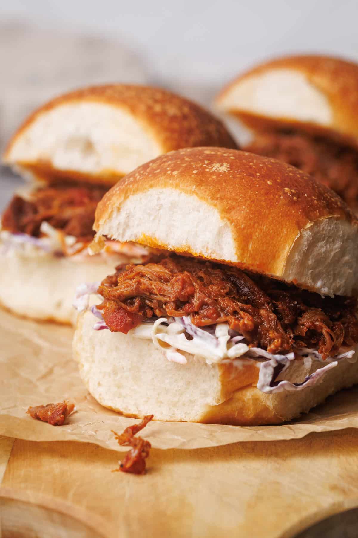 Pulled pork burgers on a wooden board.