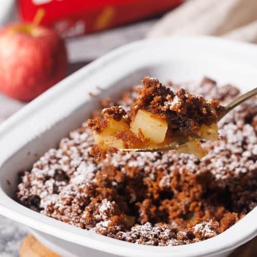 Apple crisp being scooped out of the baking dish.