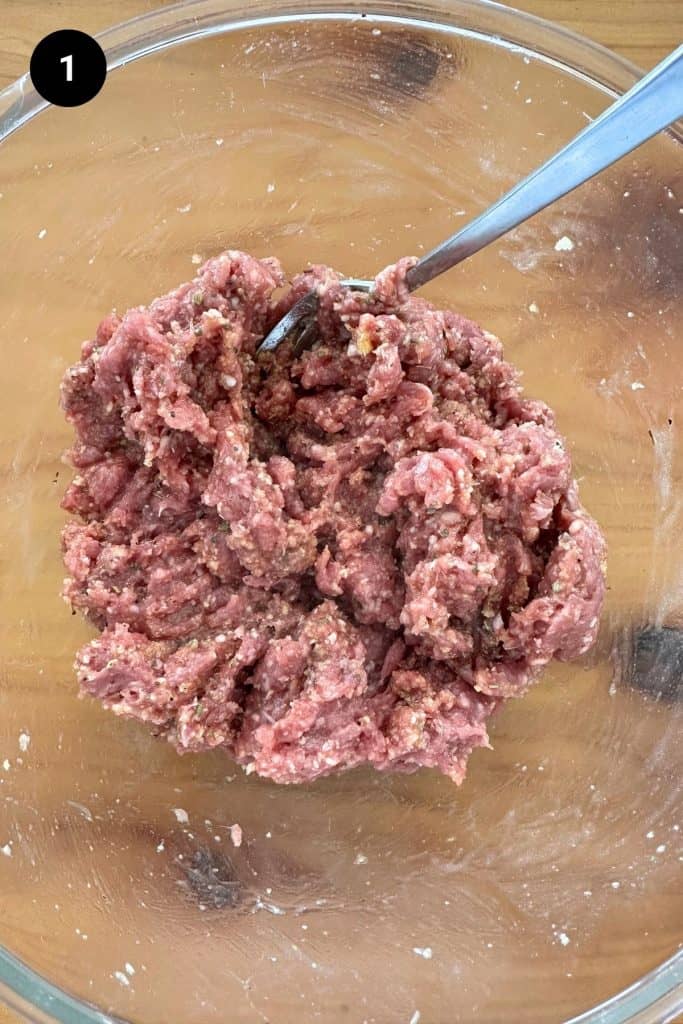 Ground meat mixed in a glass bowl.
