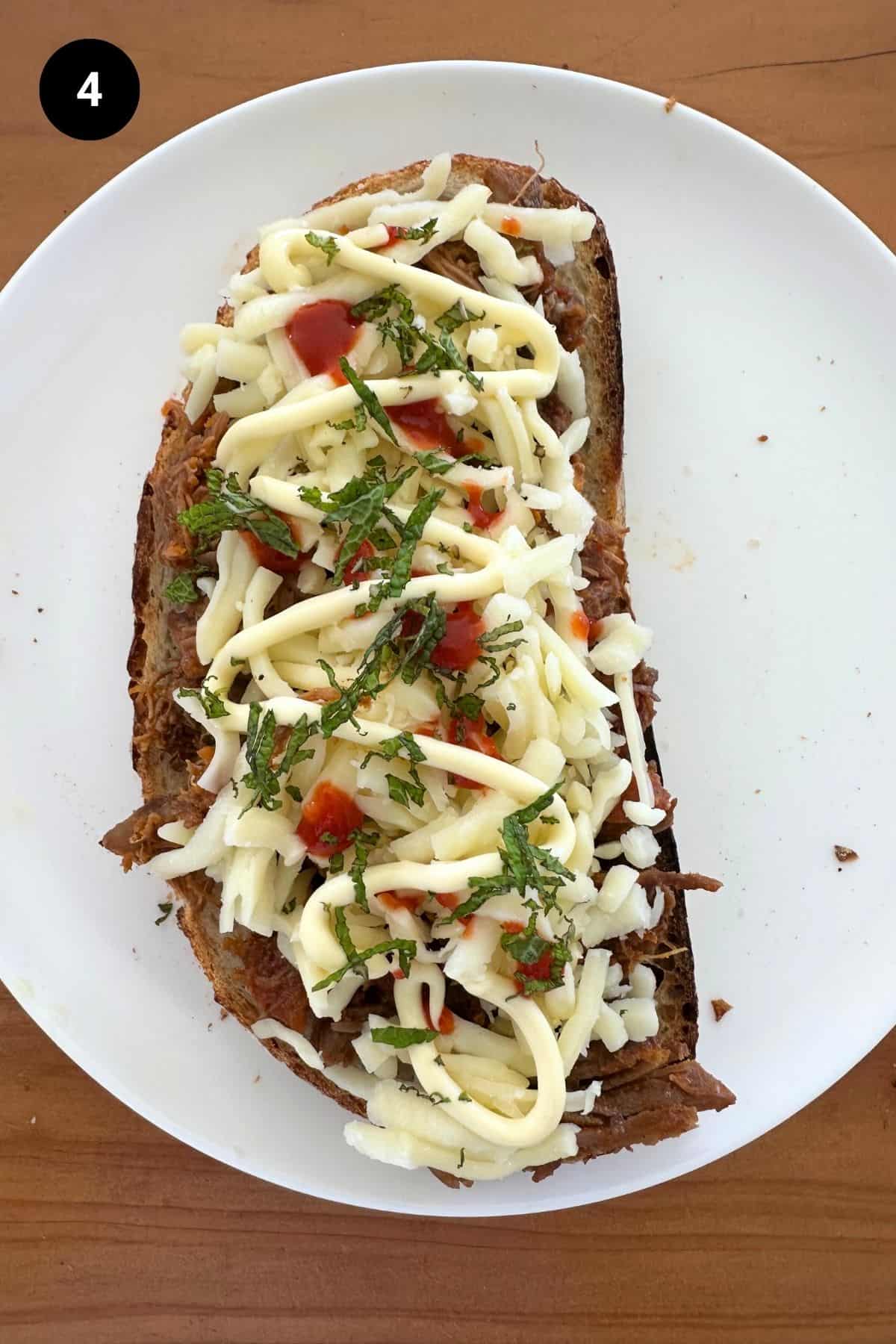 Bread slice on a white plate with fillings.