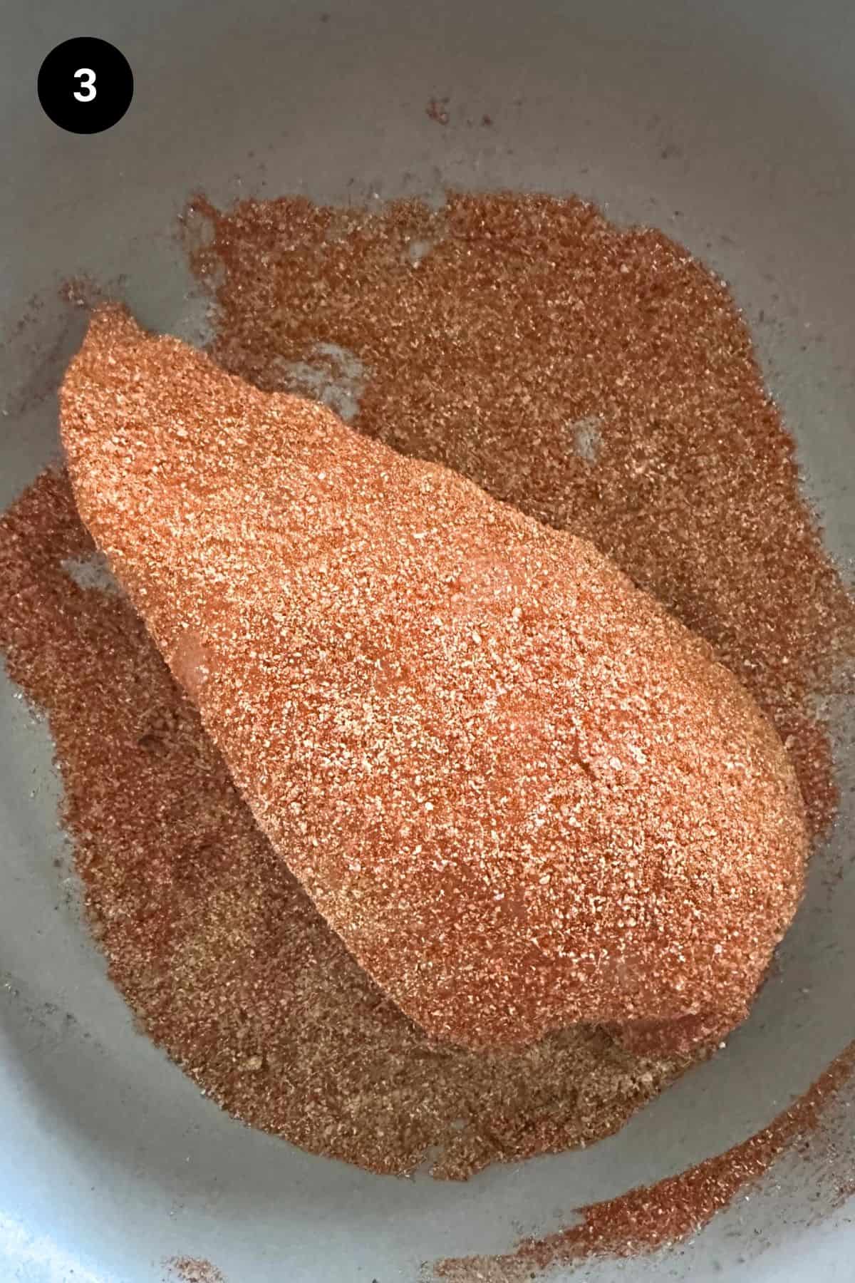 Dry rub added to chicken breast.