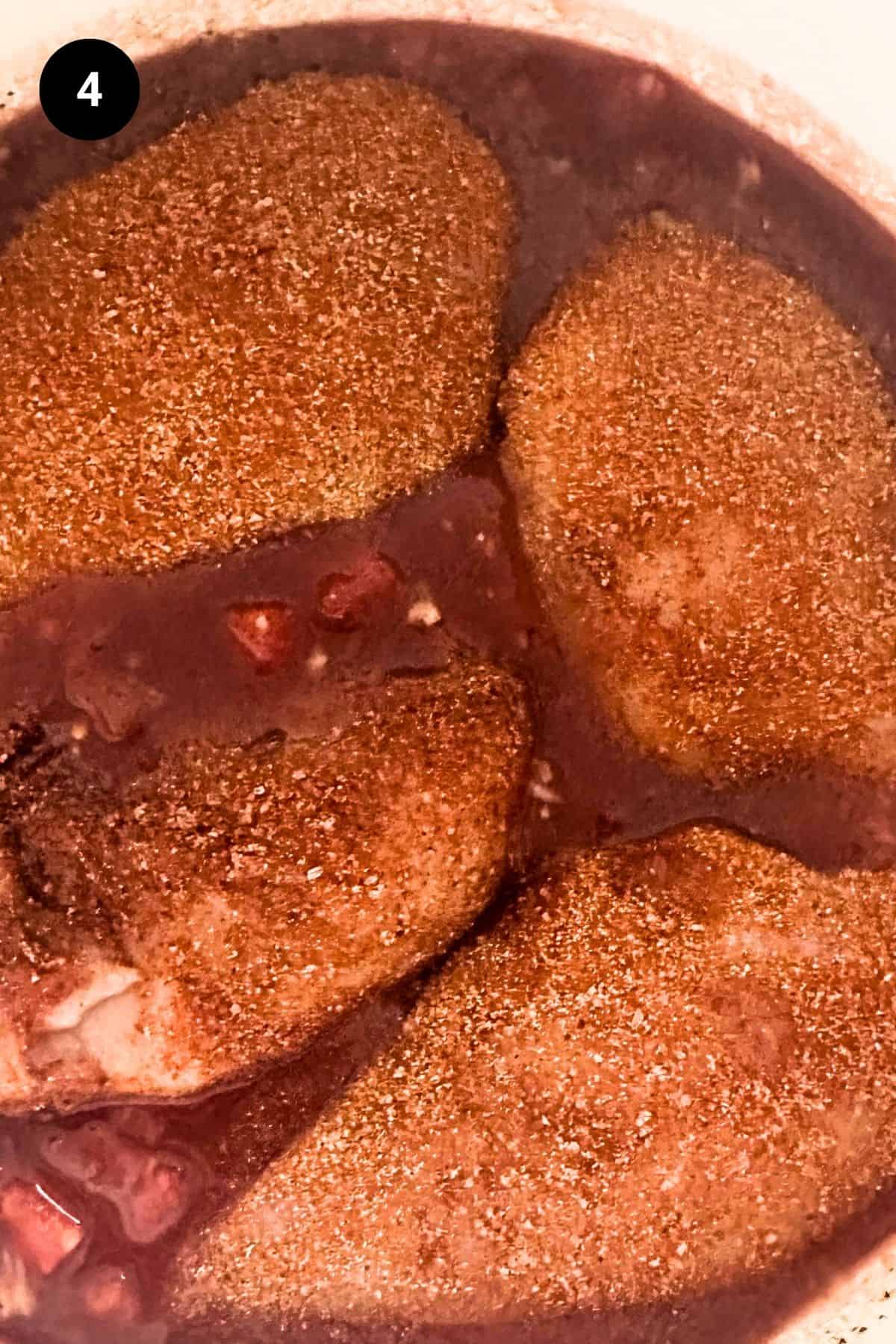 Seasoned chicken breasts in sauce.