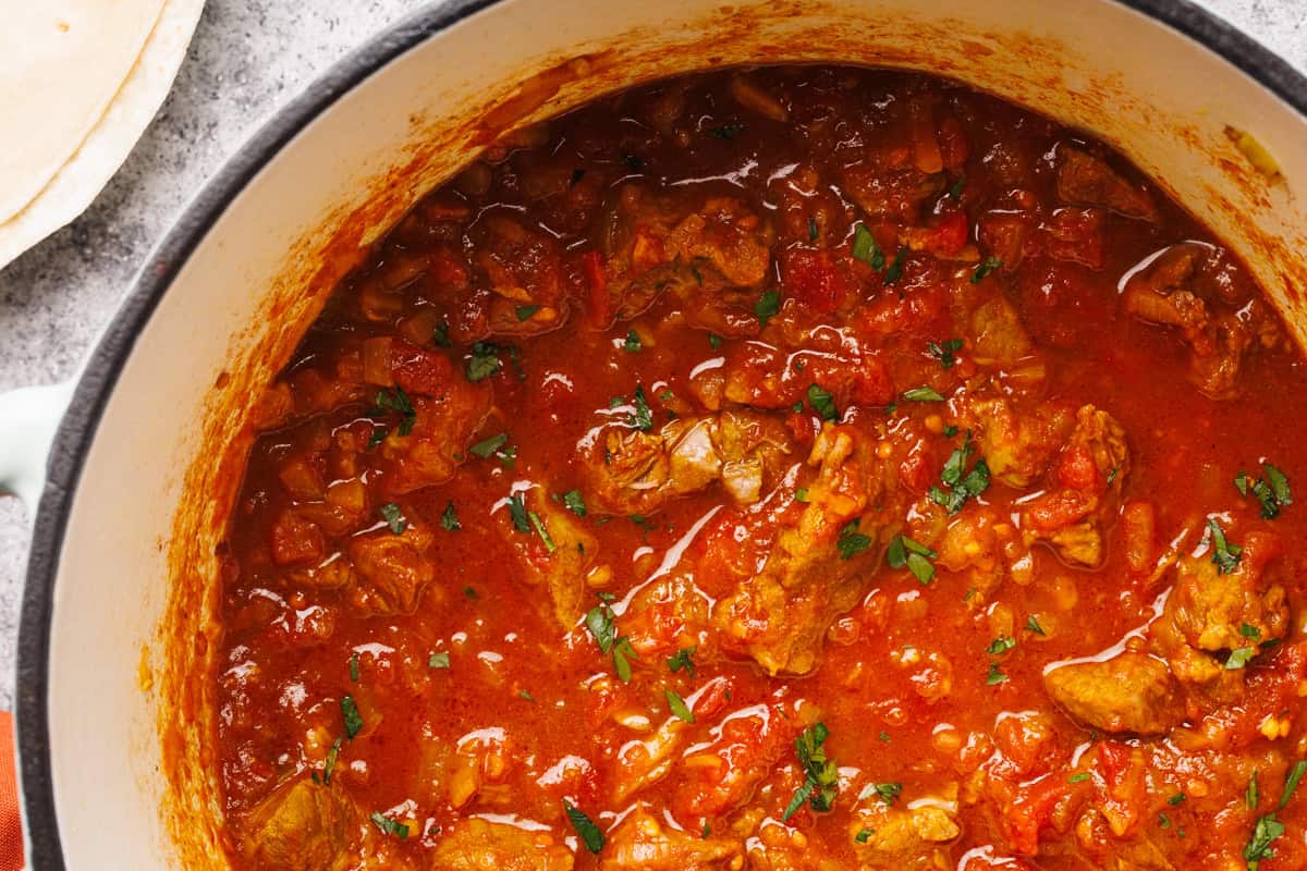 Close-up of a Dutch oven filled with lamb curry.