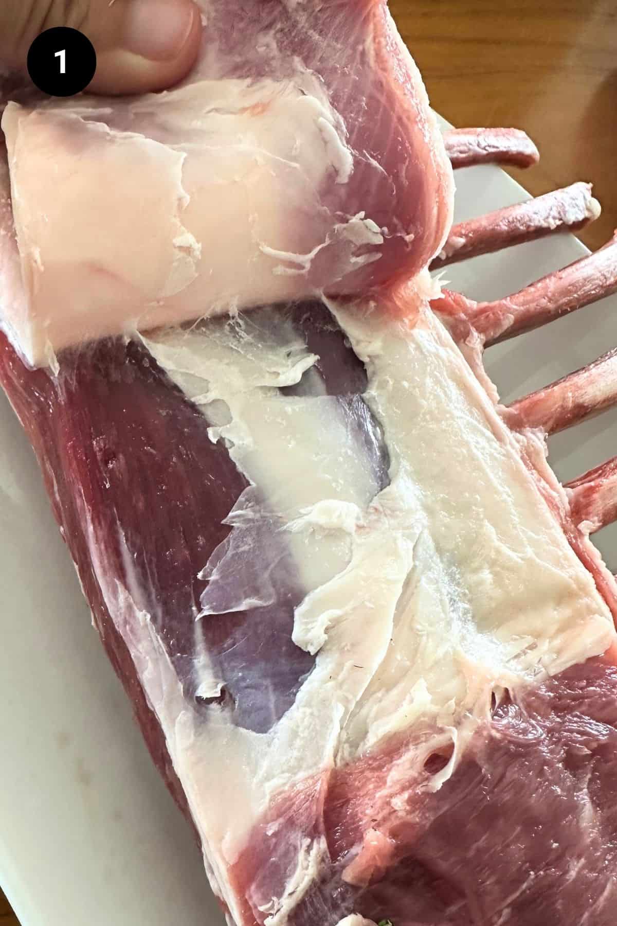 Fat cap being removed from a lamb rack.