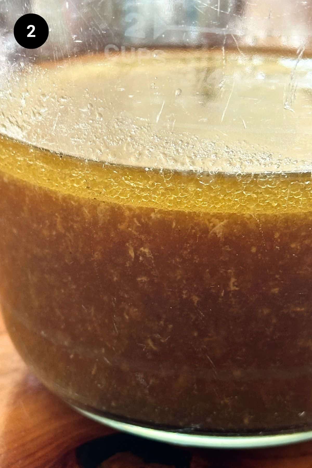 Roast juices separated from fat in a glass jug.