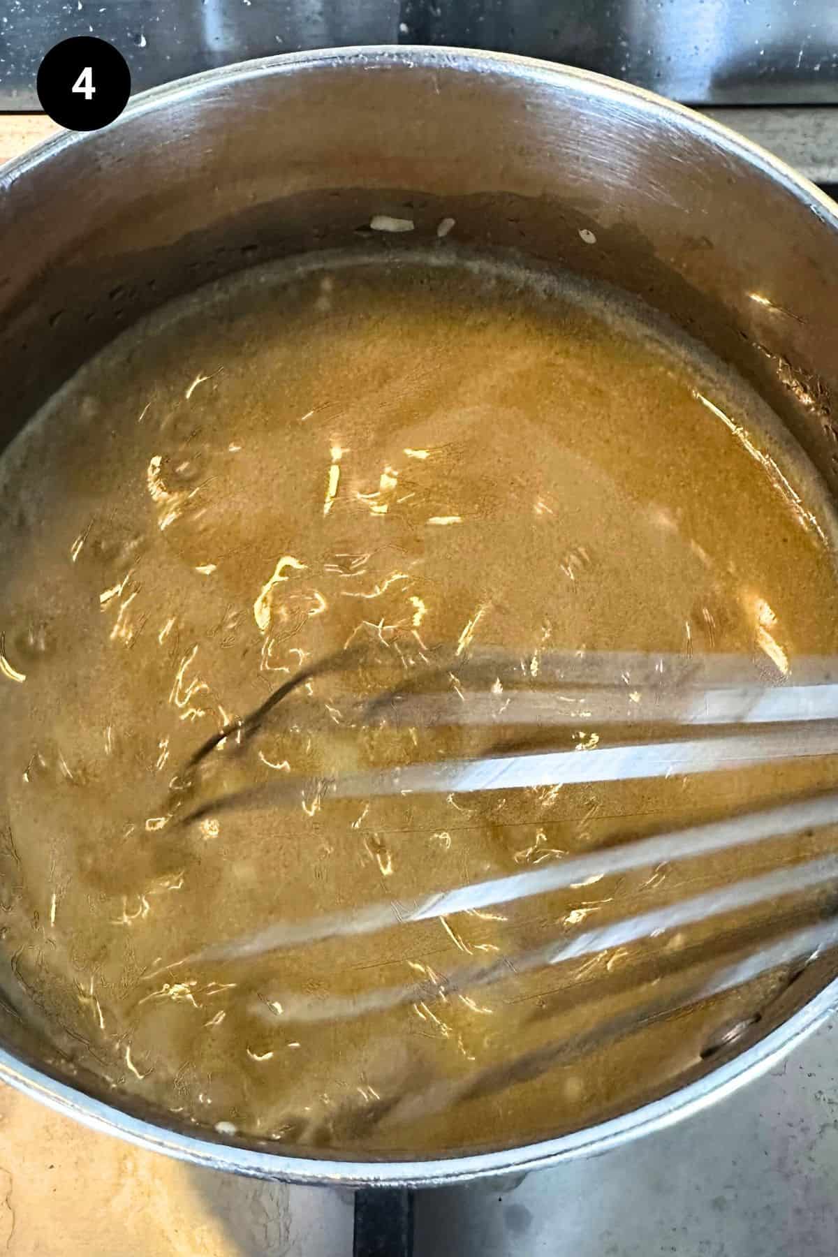 Lamb gravy being whisked.