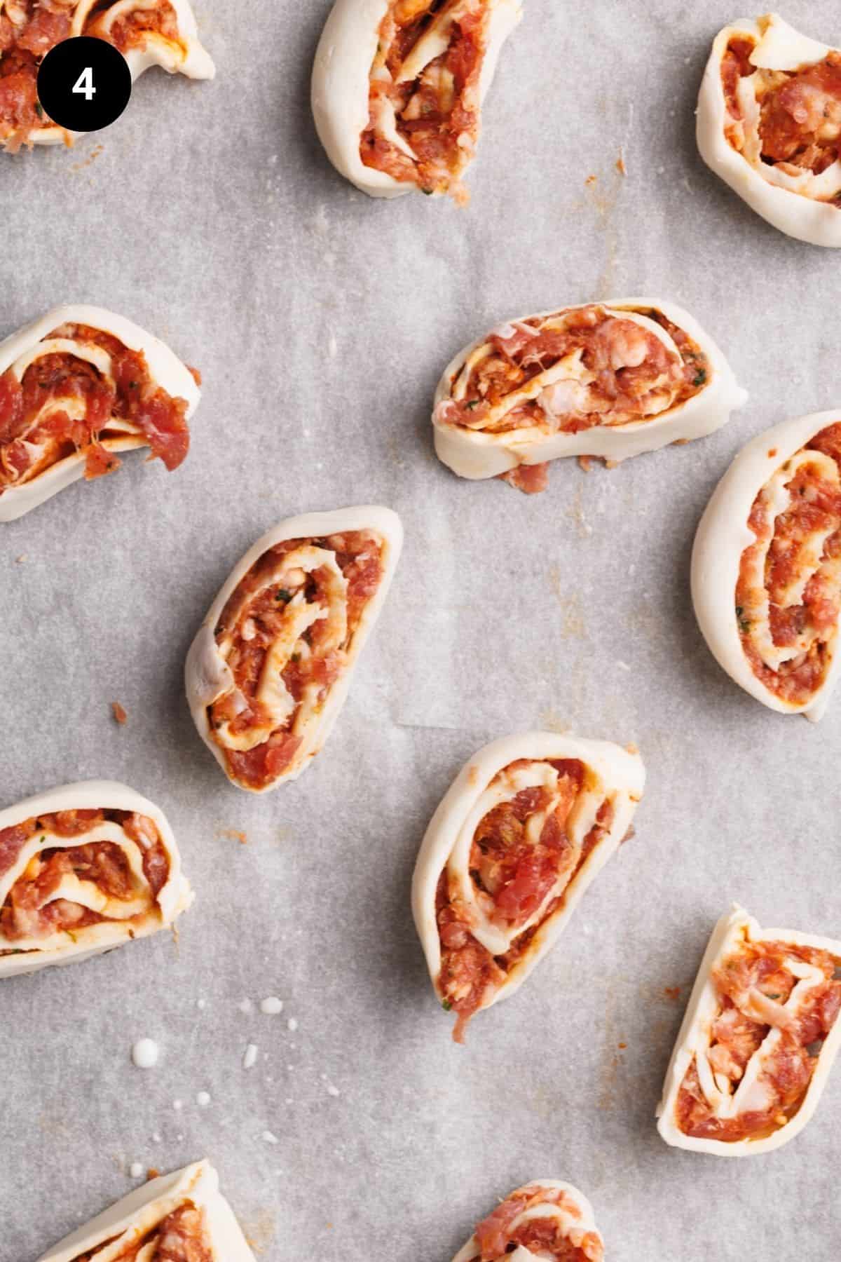 Unbaked lamb pinwheels on a baking sheet.
