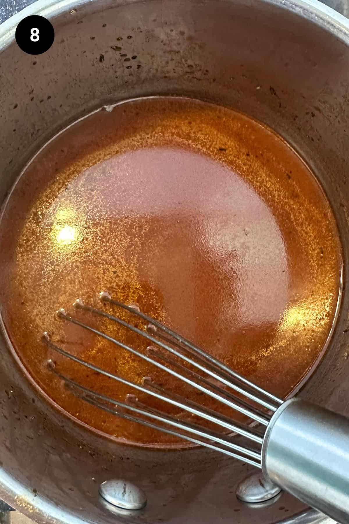 Sauce being stirred in a saucepan.