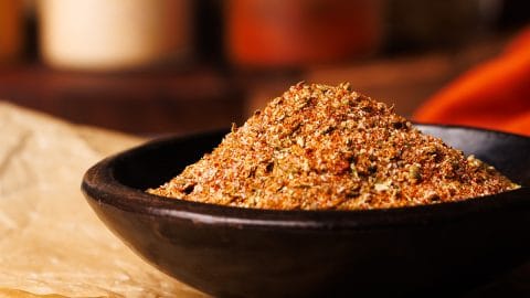 Homemade taco seasoning in a small wooden bowl.