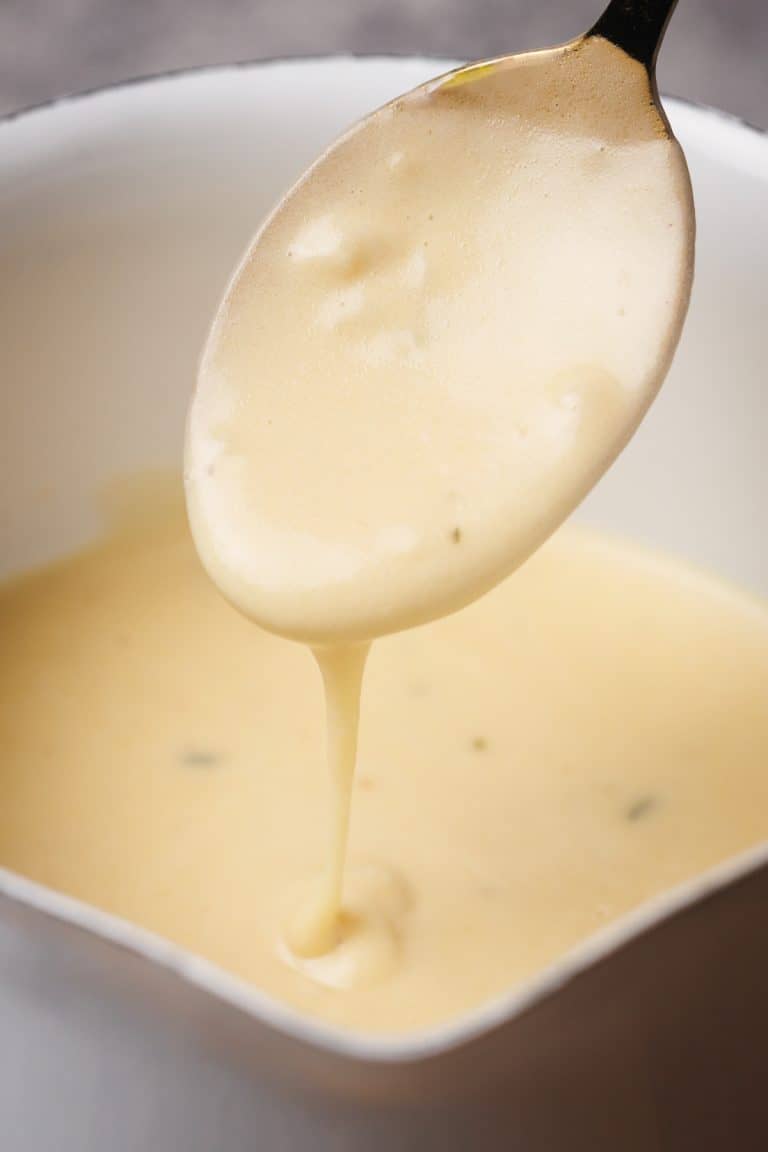 Garlic sauce being drizzled from a spoon.
