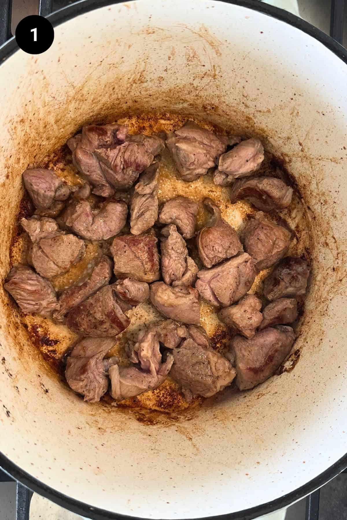 Searing the dice lamb shoulder in a Dutch oven.